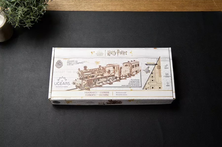 Egy Harry Potter Hogwarts Express mechanikus modell doboza sötét felületen.