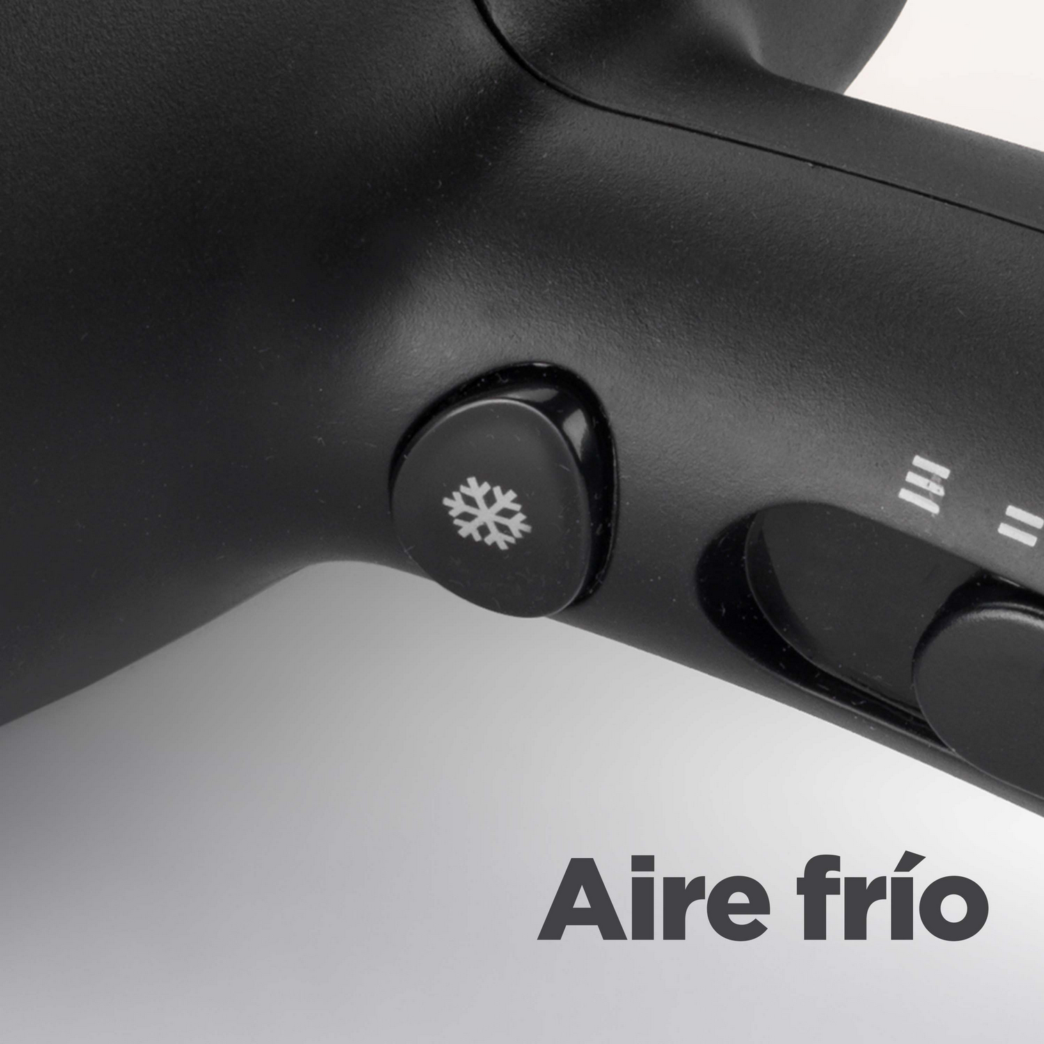 Un primer plano de un secador de pelo negro con un botón de copo de nieve y un texto: Aire frío (Aire frío).