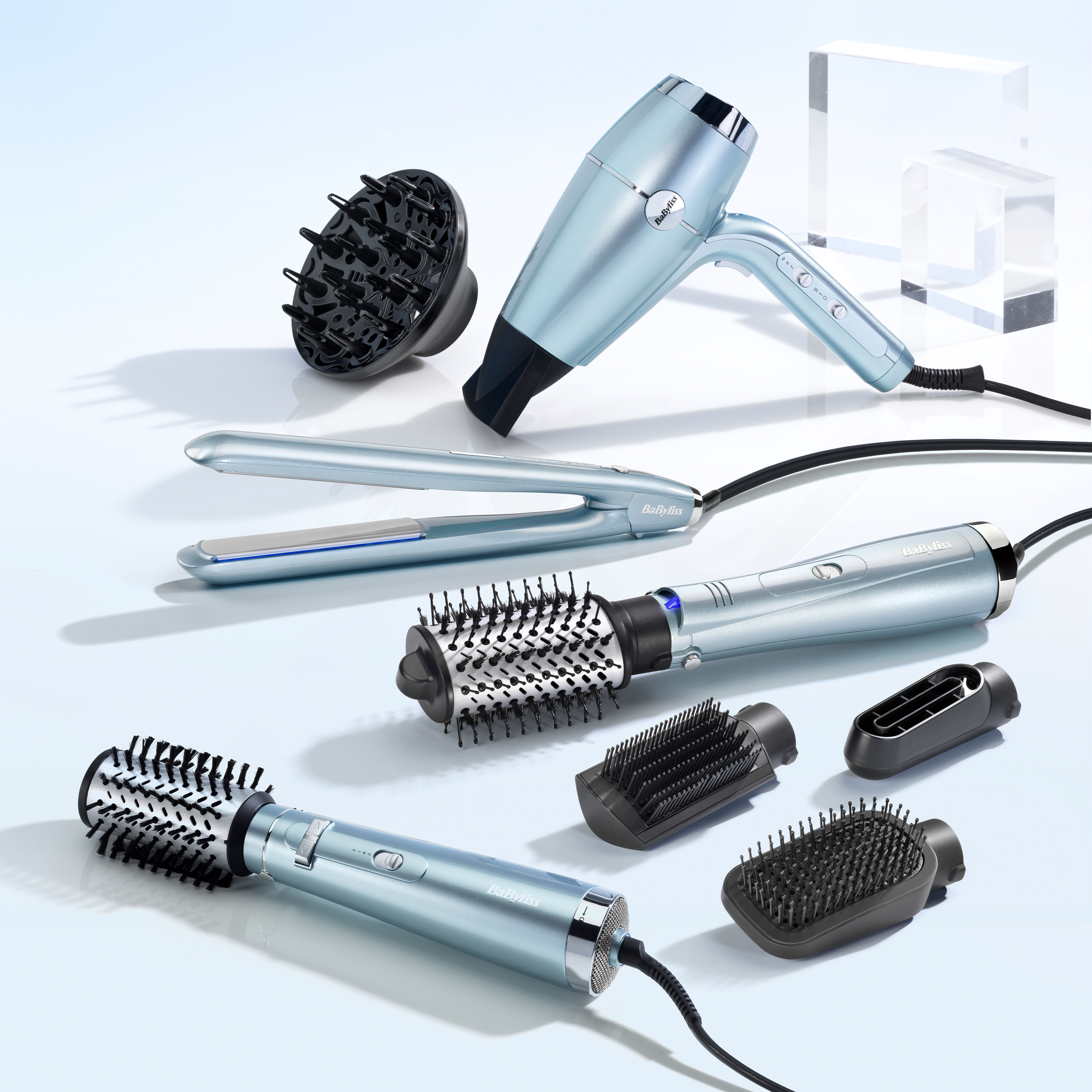 Herramientas para peinar el cabello, incluyendo secador, plancha y cepillos, todo en color azul.