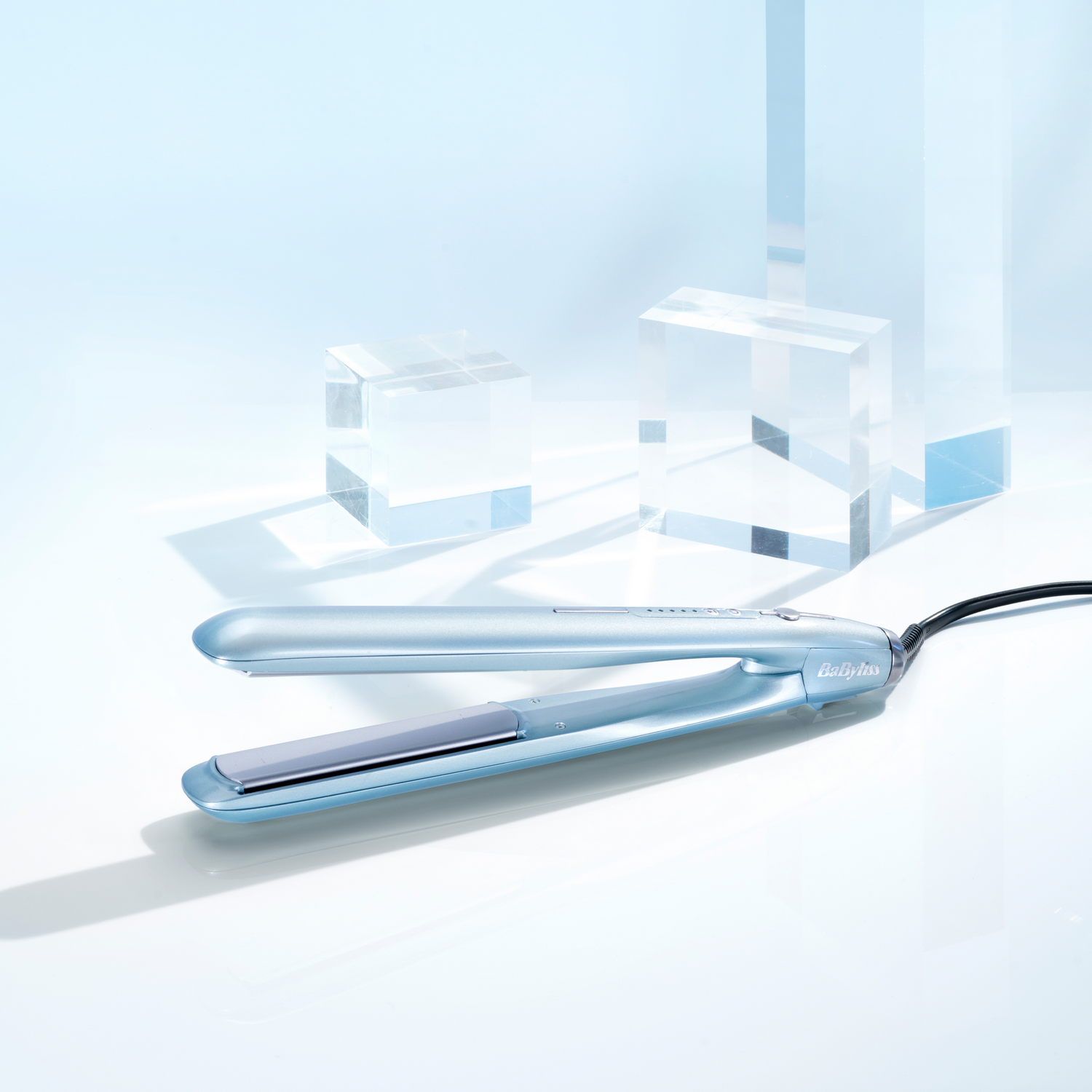 Una plancha de pelo azul claro sobre una superficie blanca, con formas geométricas claras detrás.