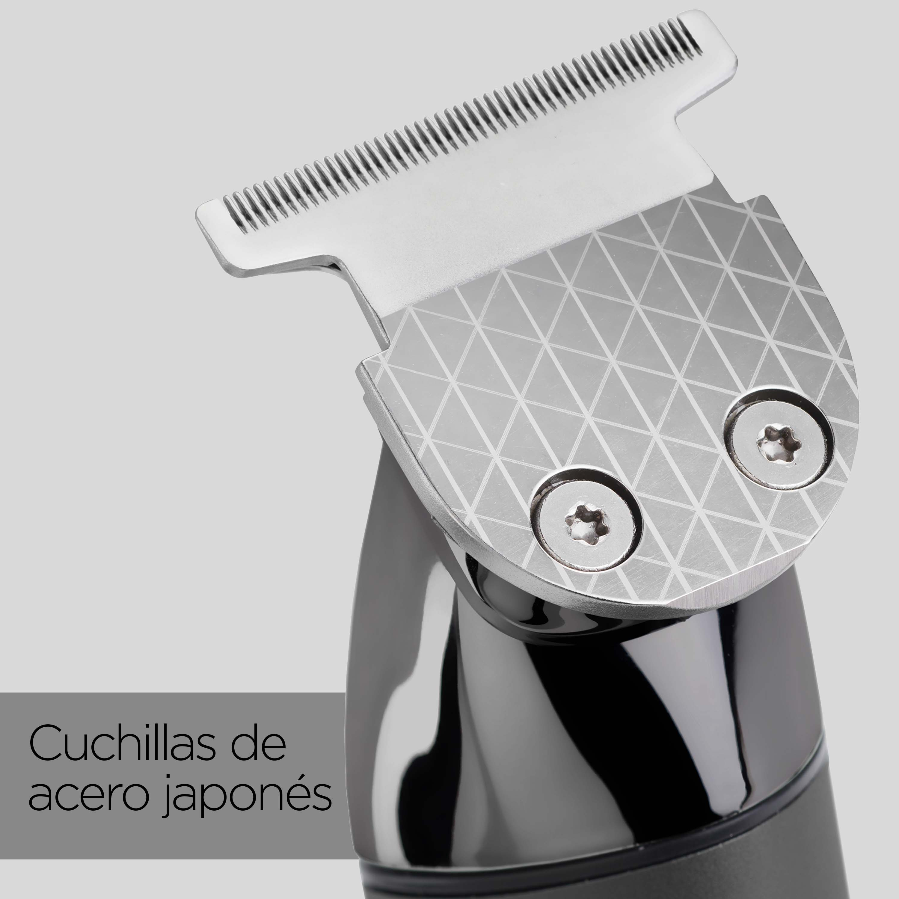 Primer plano de un recortador eléctrico negro y plateado con cuchillas de acero japonés sobre fondo gris.