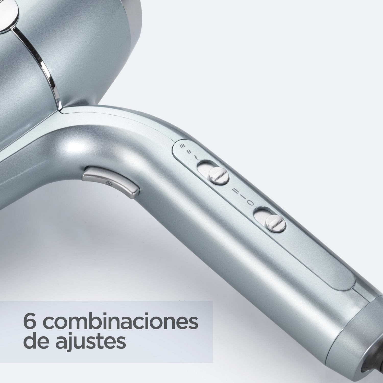 Primer plano de secador de pelo plateado con botones. El fondo es blanco.