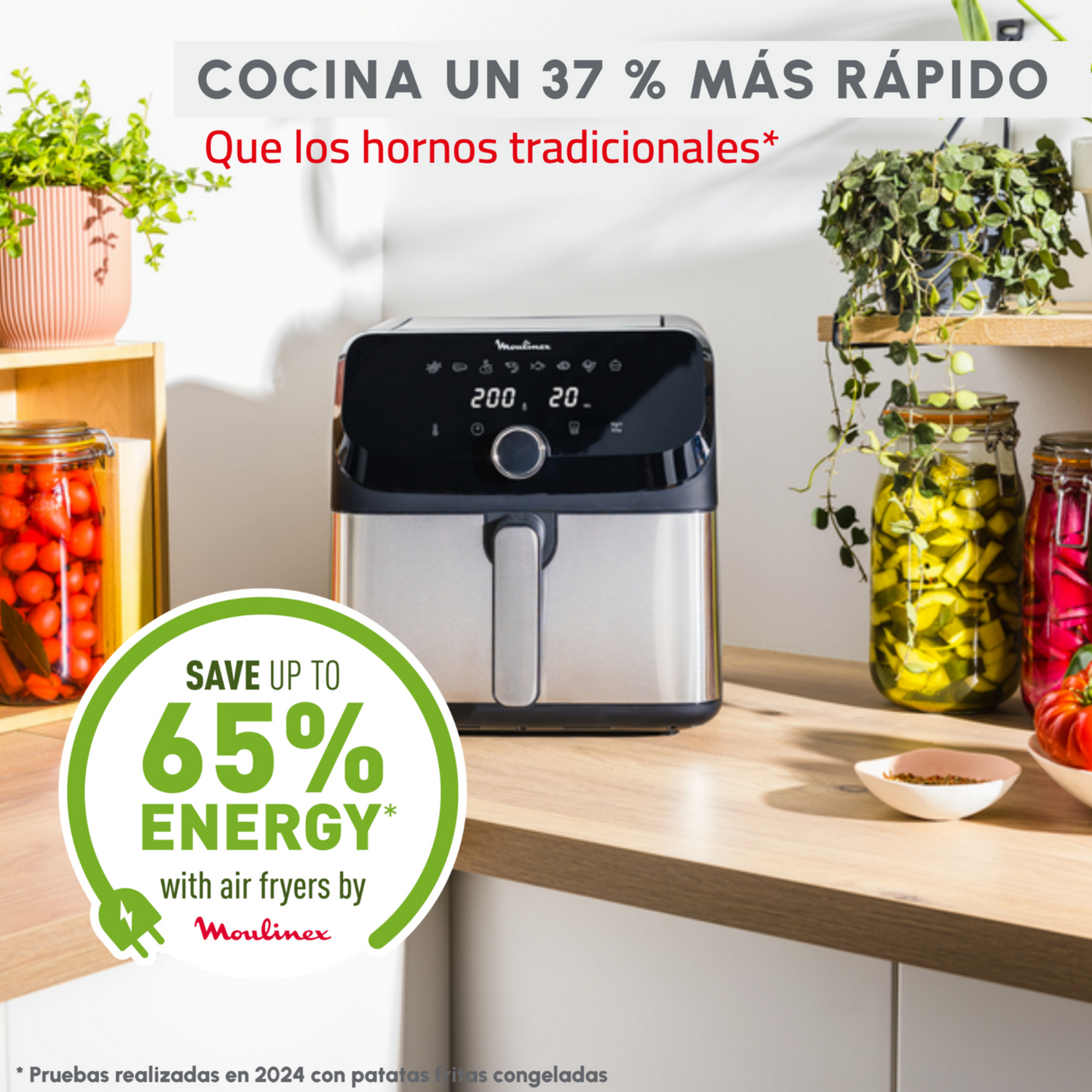 Una freidora de aire sobre una encimera, con plantas en macetas y frascos de comida en el fondo.