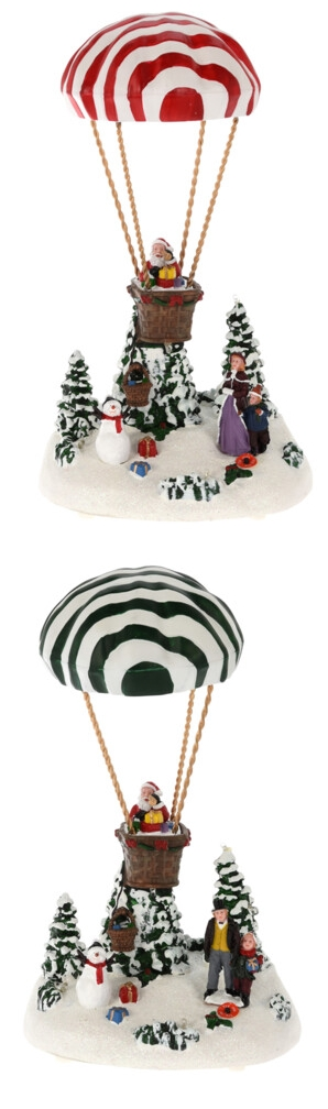 A figura egy téli jelenetet ábrázol hőlégballonnal, hóval, fákkal és emberekkel.