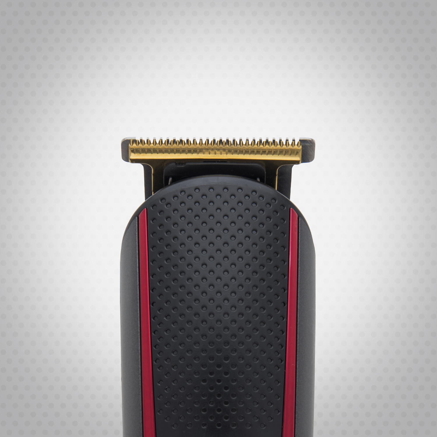 Primer plano de un recortador de barba negro y rojo con cuchilla dorada, sobre fondo punteado blanco.