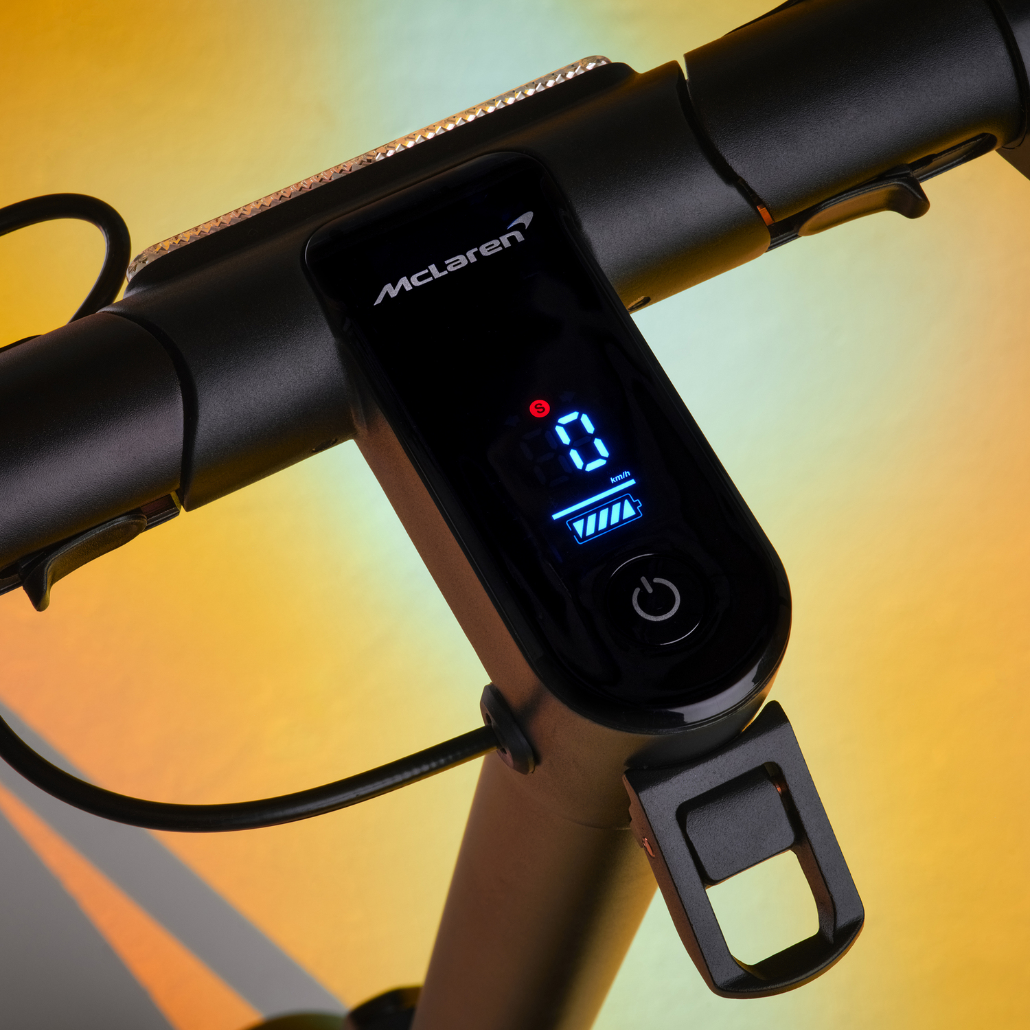 Scooter handlebar with a display showing speed and battery charge. Black, with McLaren branding.