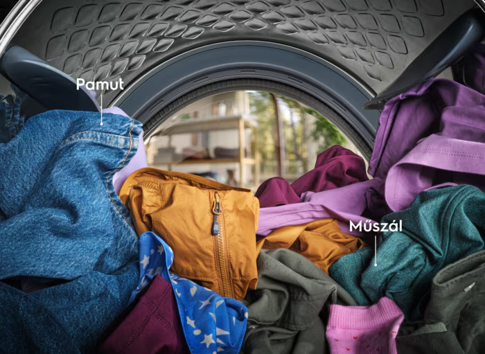 Egy mosógép belseje színes ruhákkal. A címkék a 