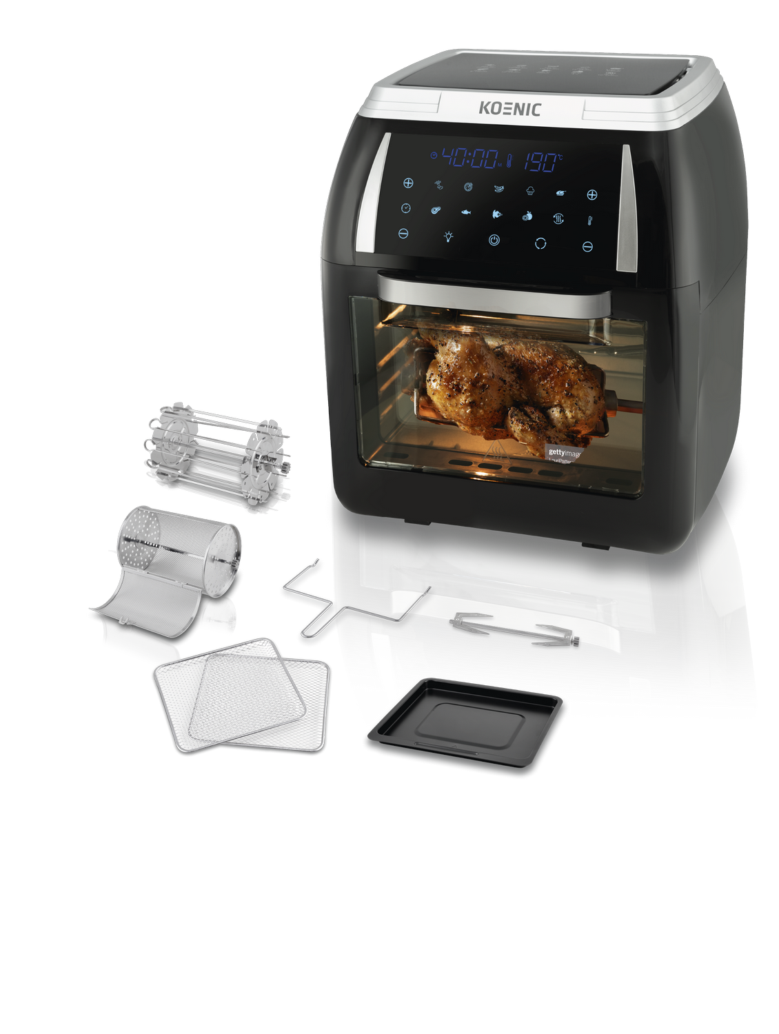 Freidora de aire negra con pollo asado dentro y accesorios al frente. Pantalla digital.