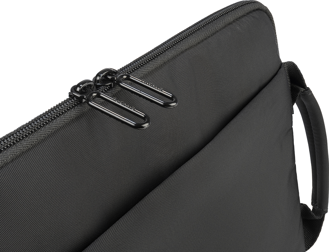 Sacoche d'ordinateur portable noire, gros plan sur la fermeture éclair et la poignée, vue en angle sur fond blanc.