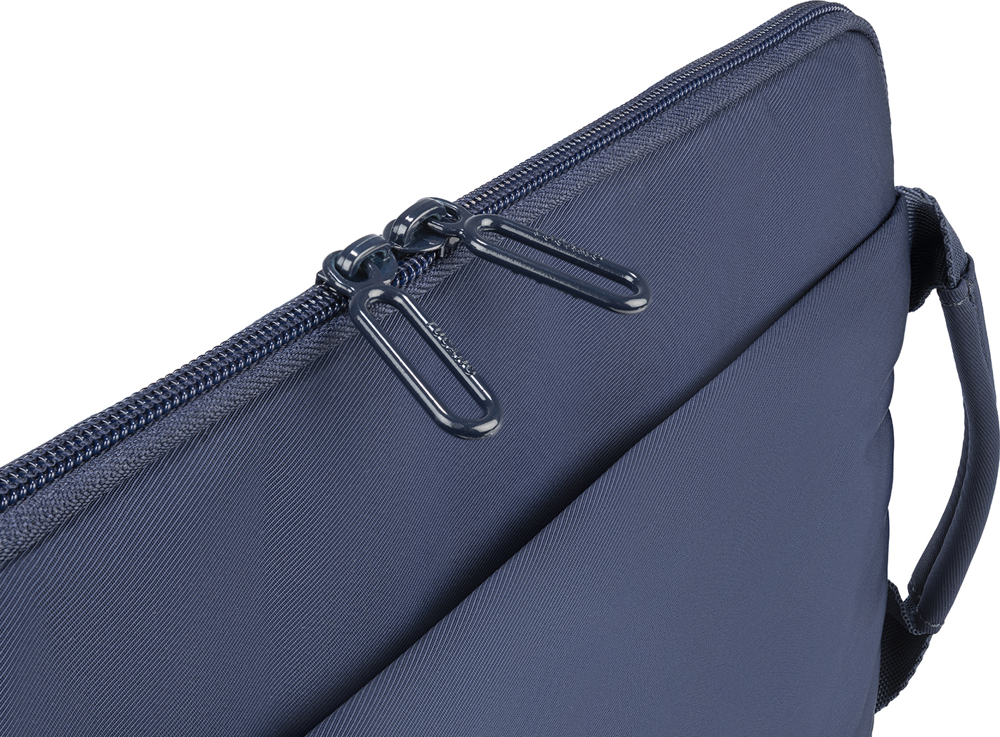 Gros plan sur un sac pour ordinateur portable bleu foncé avec deux fermetures éclair en métal et une poignée.