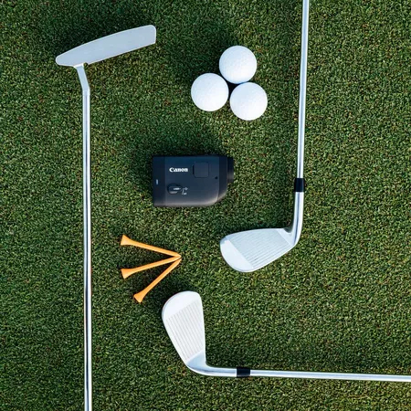 Golfausrüstung auf grünem Gras: Putter, Golfbälle, Tees und Schläger.