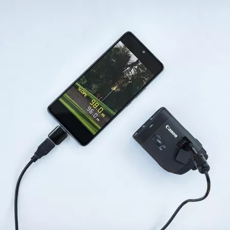 Ein Telefon, verbunden mit einer Canon-Kamera und einem USB-Kabel, zeigt Golfplatzinfos an.