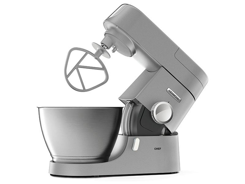 Grauer Kenwood Chef Küchenmixer mit einer Rührschüssel und einem Schneebesenaufsatz, vor weißem Hintergrund.