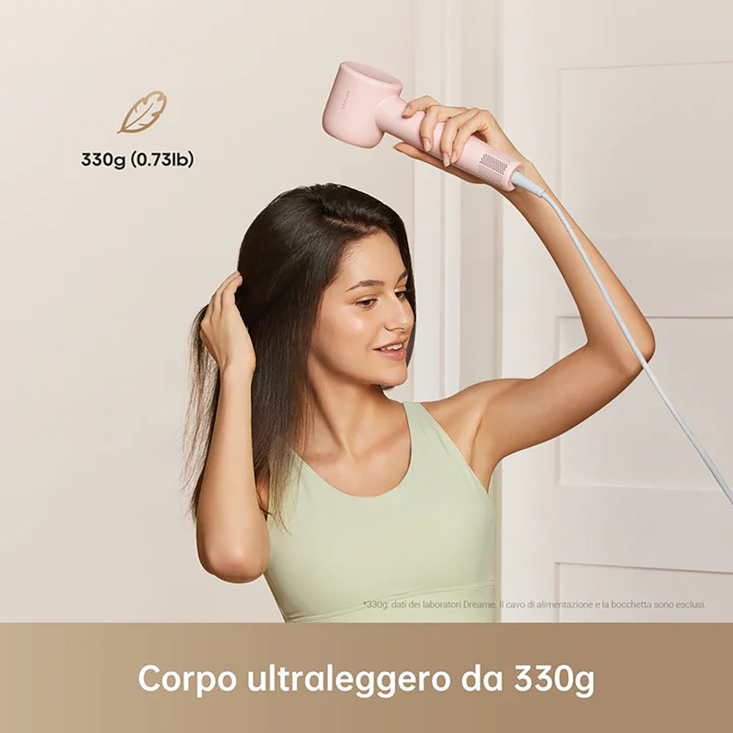 Una donna si asciuga i capelli con un asciugacapelli rosa, lo sfondo è beige.