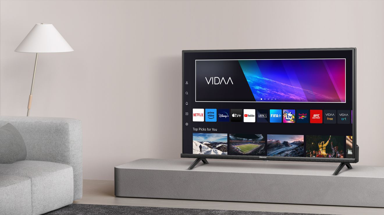 Egy fekete TV alkalmazásokkal a képernyőn, szürke állványon, fehér lámpával.
