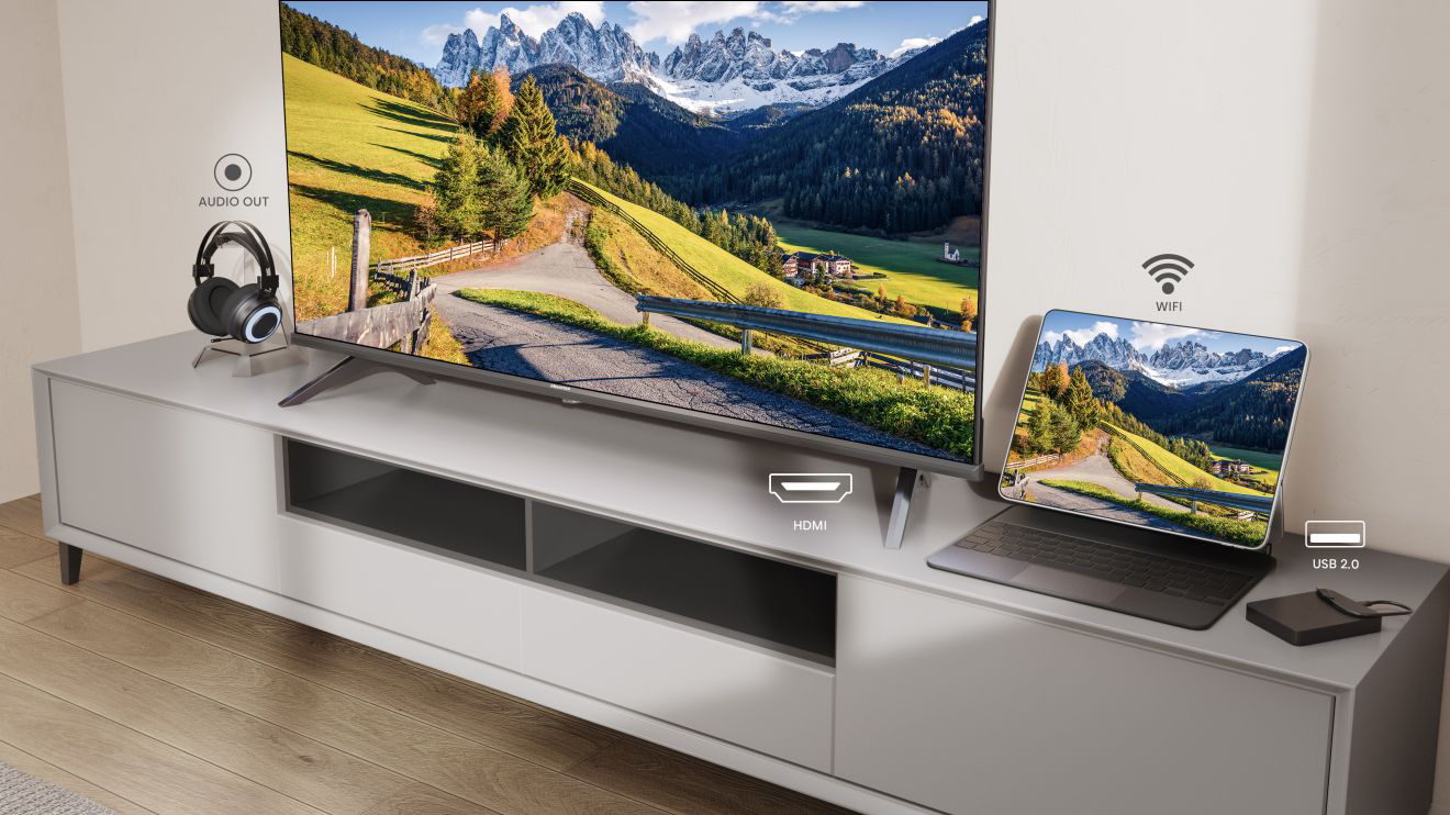 TV egy fehér szekrényen tablettel, fejhallgatóval és kiegészítőkkel.