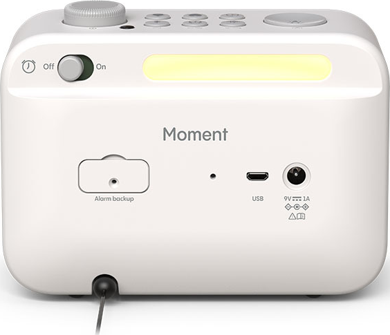 Un réveil Moment blanc avec écran numérique, port USB et détails de sauvegarde d'alarme.