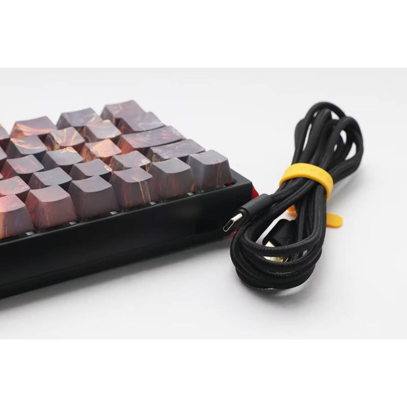 Un teclado con teclas coloridas y un cable en espiral con una brida amarilla.