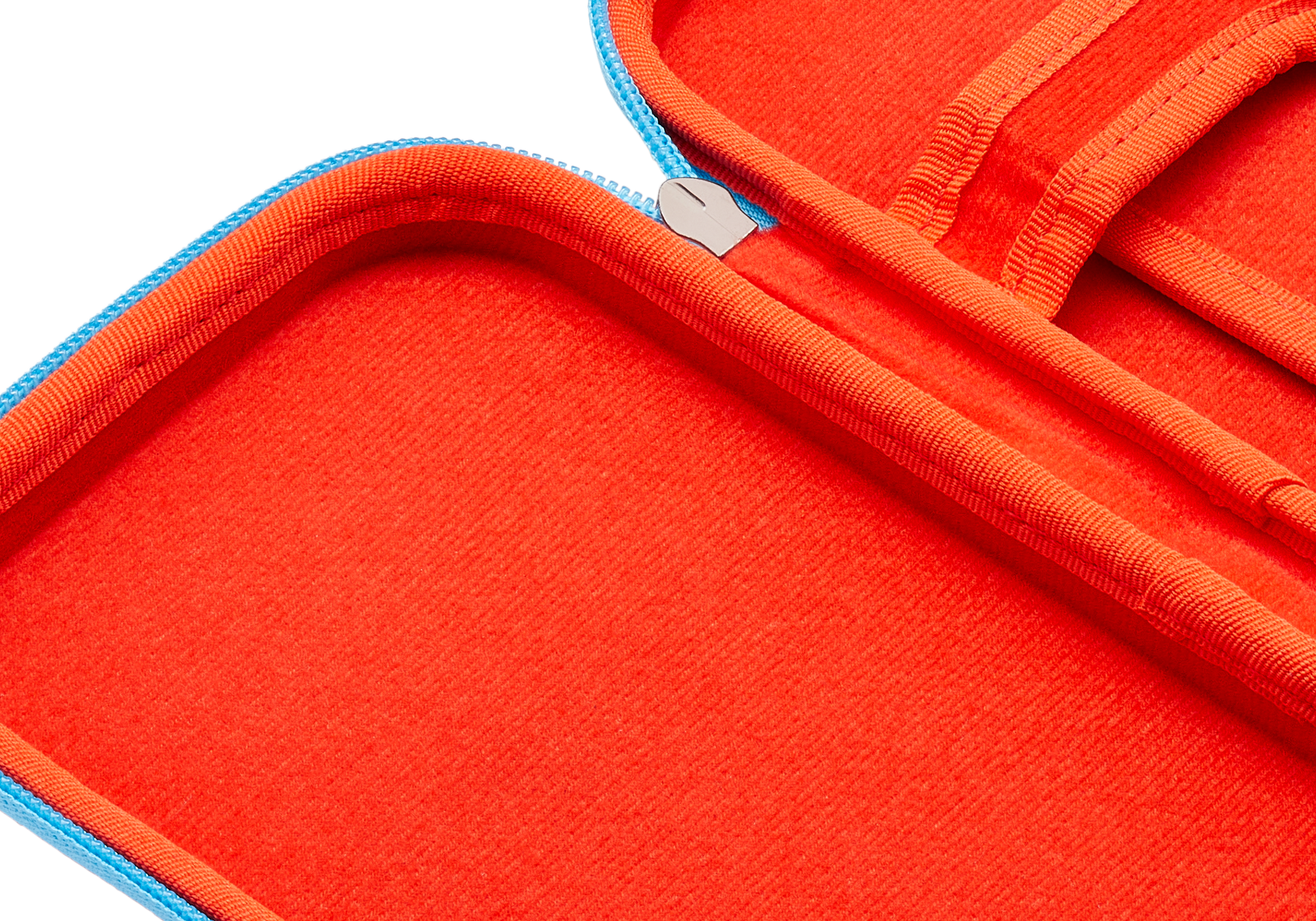 Nahaufnahme eines roten Materials mit blauem Rand und silbernem Reißverschluss.