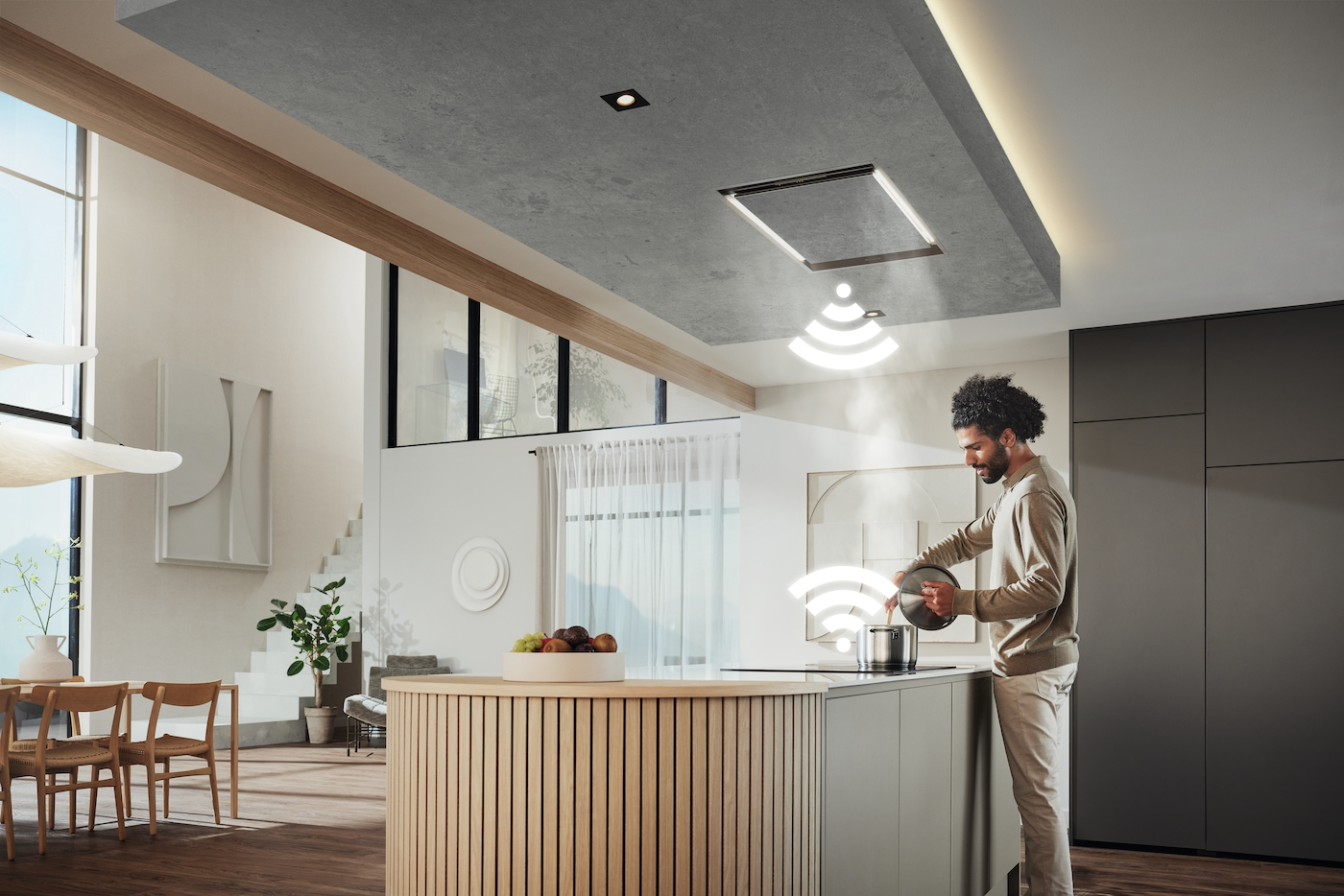 Mann kocht in einer modernen Küche mit Deckenlüfter und WLAN-Symbolen.