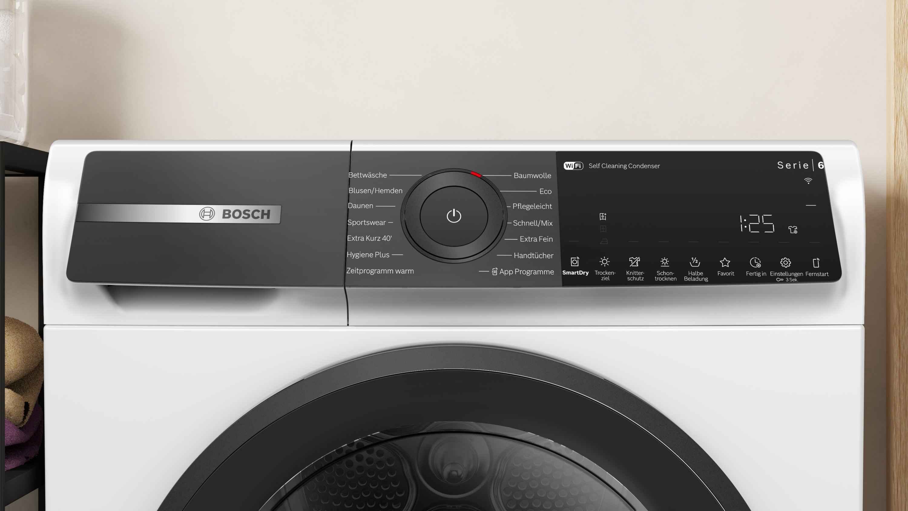 Ein weißer Bosch Serie 6 Trockner mit schwarzem Bedienfeld. Er hat verschiedene Einstellungen und eine Digitalanzeige.