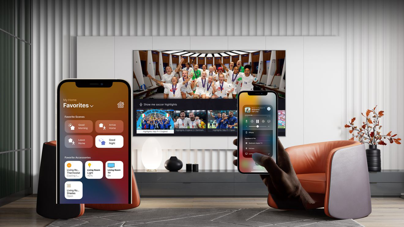 Két telefon okosotthon felületet jelenít meg, a háttérben egy TV-vel.