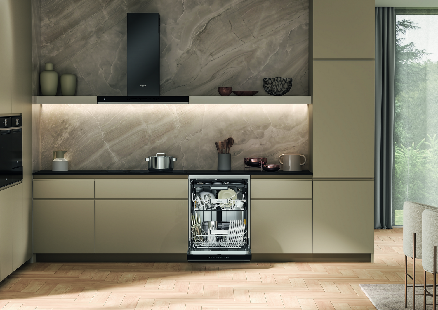 Cocina moderna con lavavajillas abierto. Gabinetes beige, pared de mármol, campana negra y piso de madera.