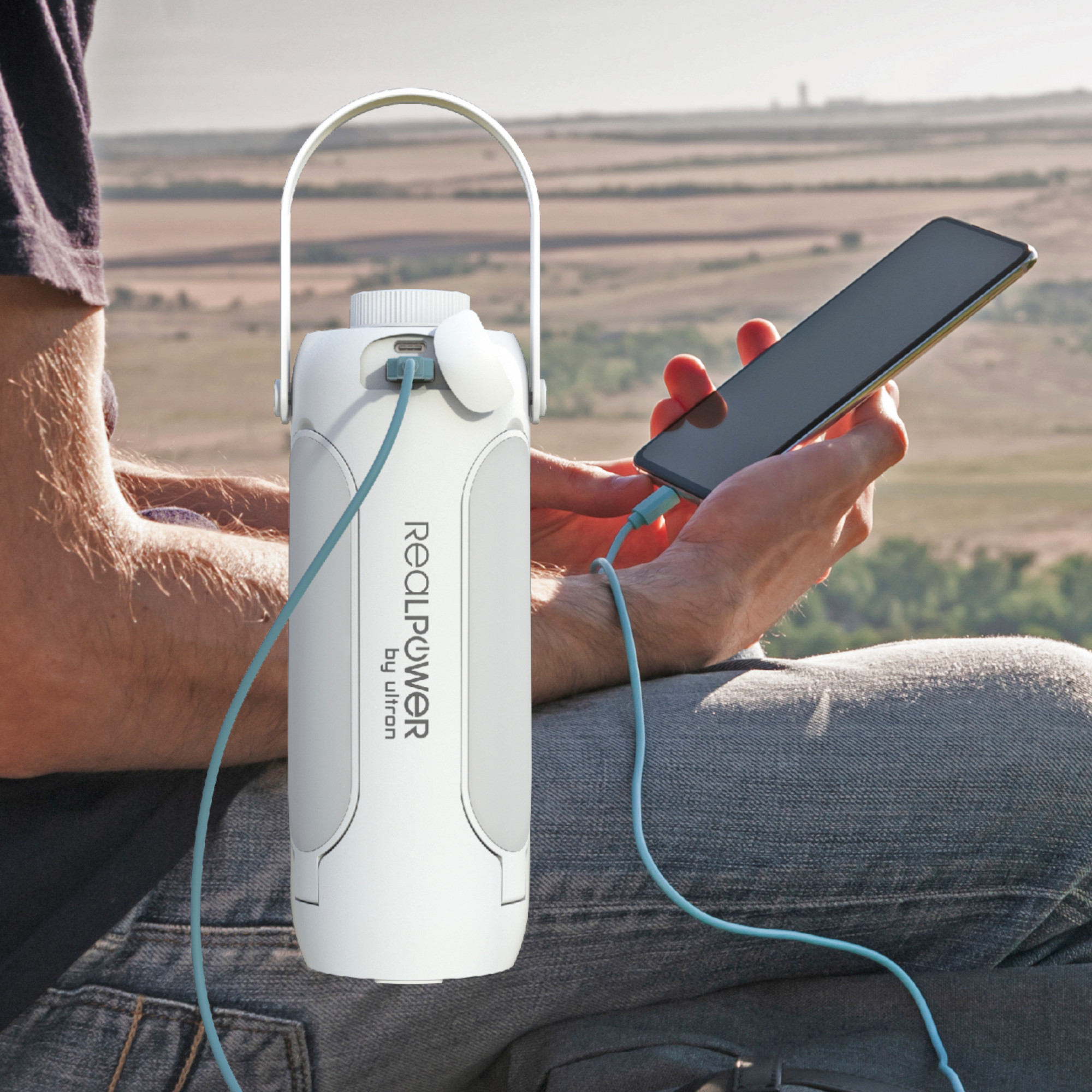 Ein Mann lädt sein Handy mit einer Powerbank in einer natürlichen Umgebung auf.