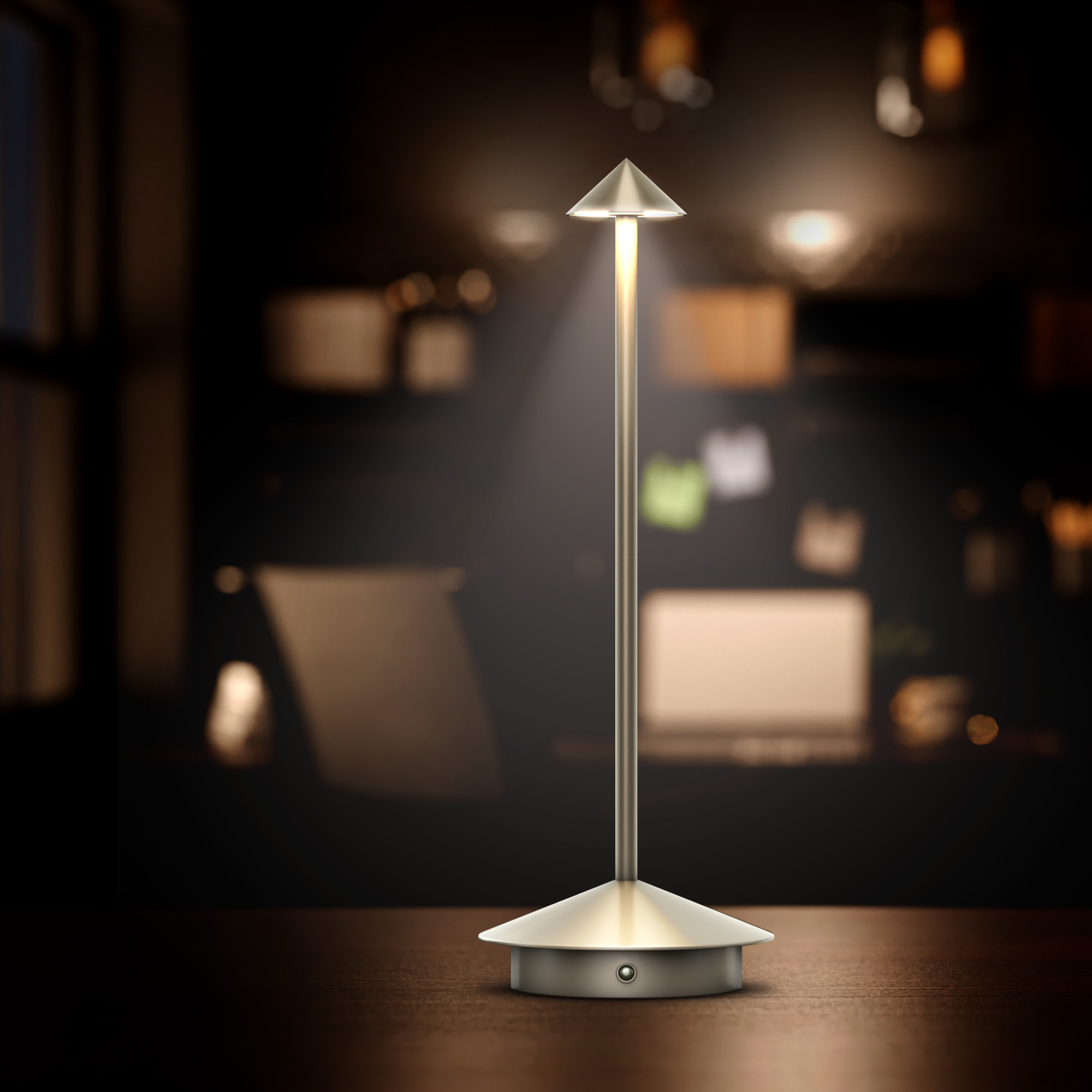 Eine silberne Tischlampe mit konischem Kopf, die ein warmes Licht auf einem dunklen Schreibtisch wirft.