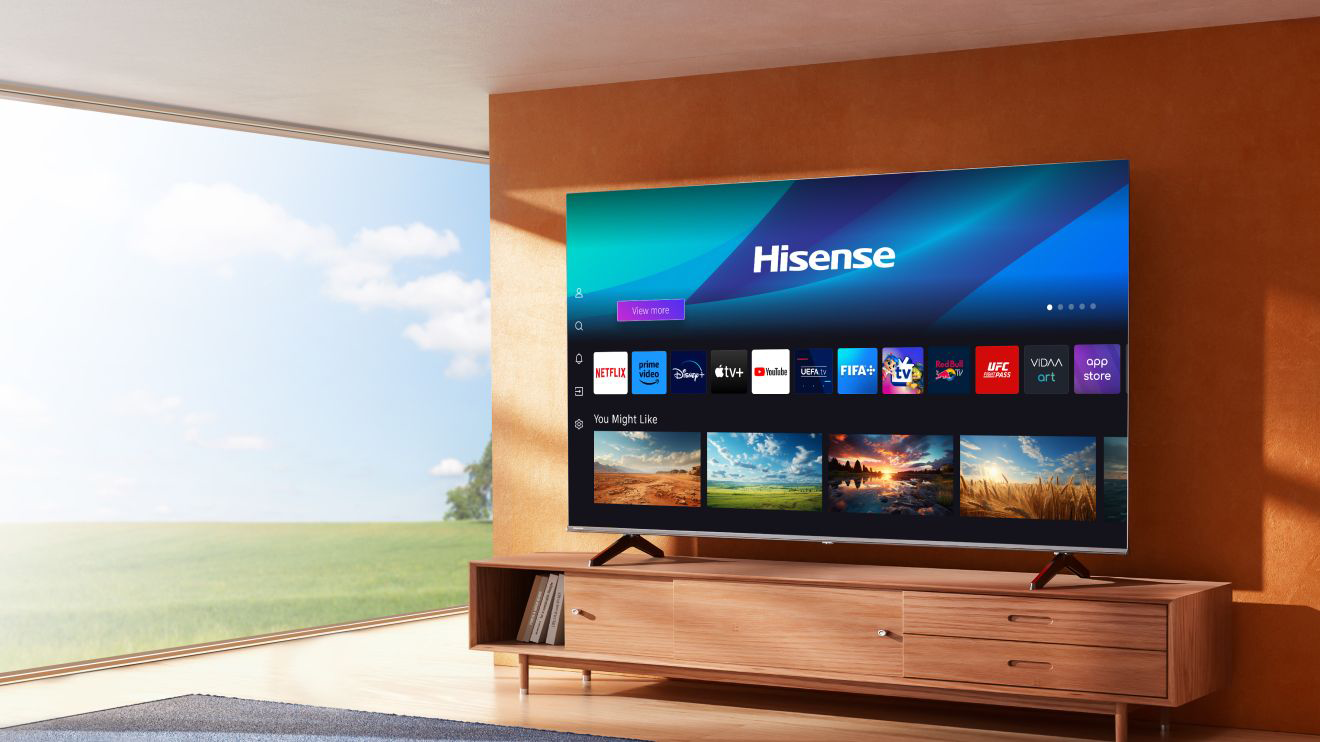 Nagyképernyős TV felhasználói felülettel, egy fa szekrényen egy otthonban.