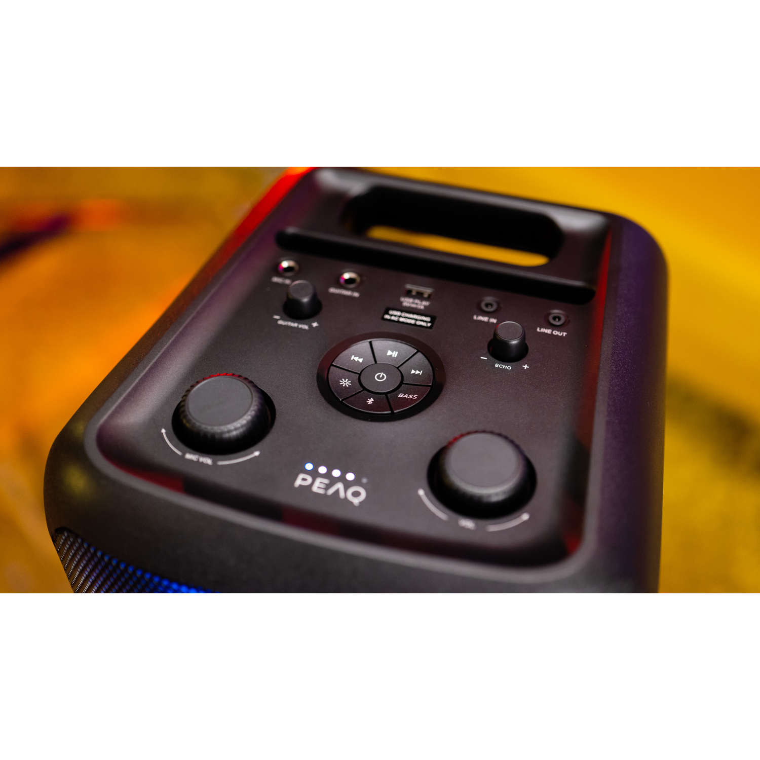 Black speaker close-up with buttons. Controls for volume, bass and music.