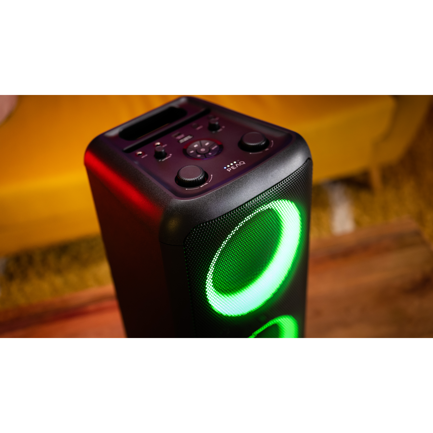 Black speaker with illuminated green circles and control buttons. Yellow background.