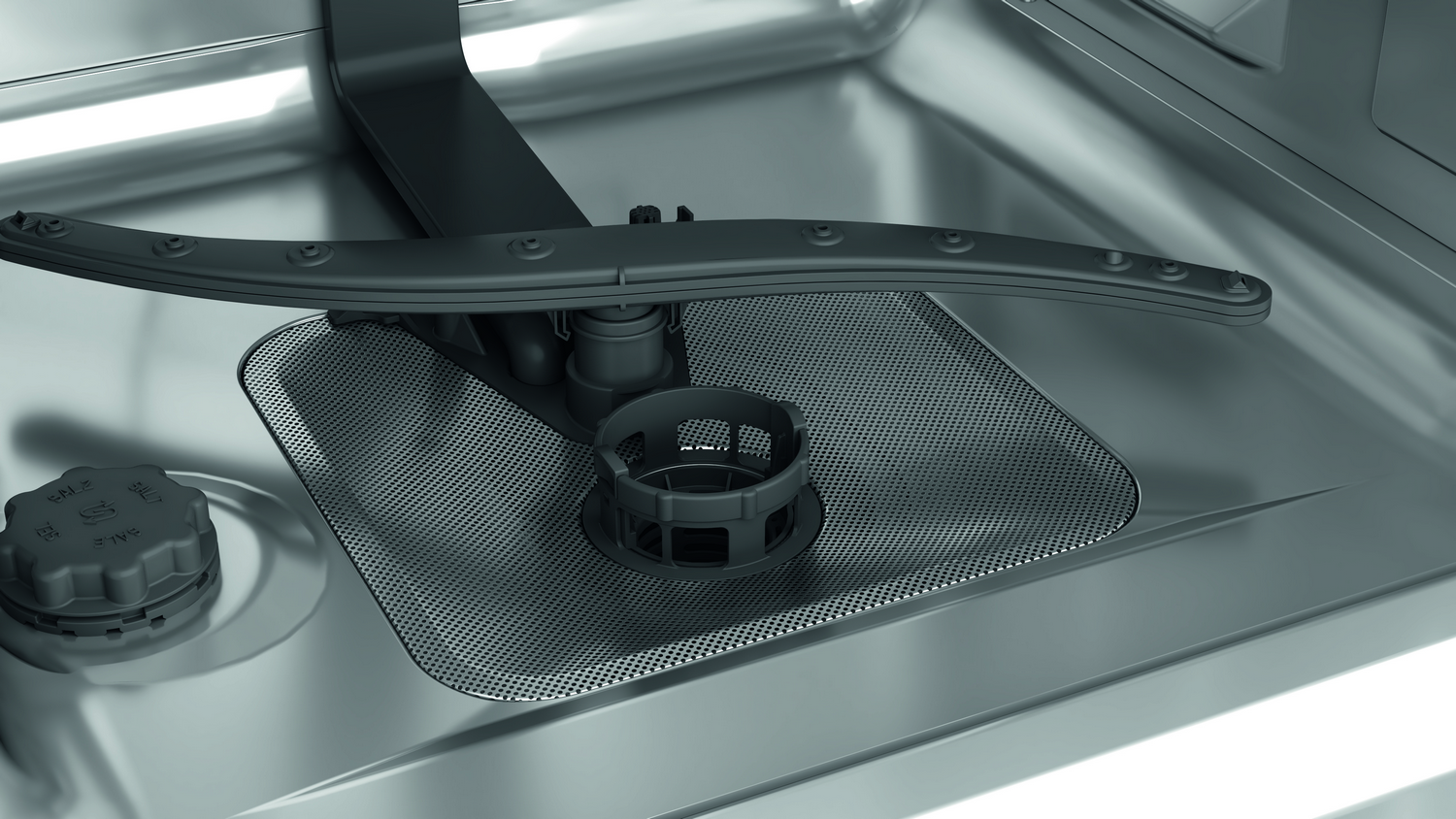 Primer plano del interior de un lavavajillas con un brazo rociador y filtro, todo en acero inox.