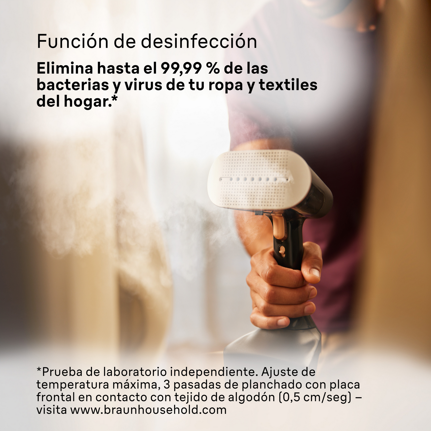 Persona sosteniendo un vaporizador de ropa blanco y negro. Vapor visible, texto en el lateral.