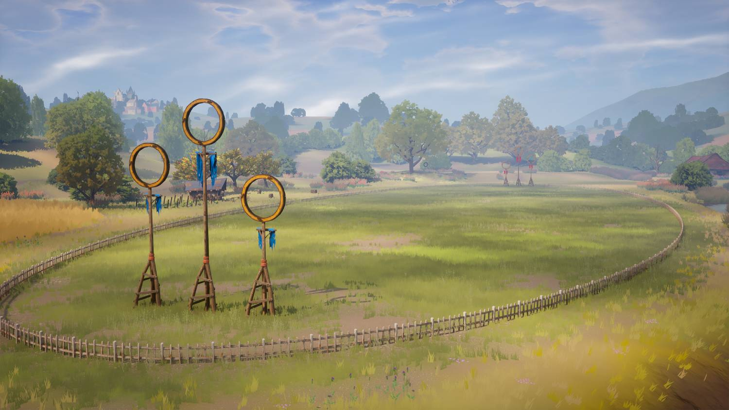 Un campo de Quidditch con tres aros. El cielo es azul, y hay árboles alrededor.