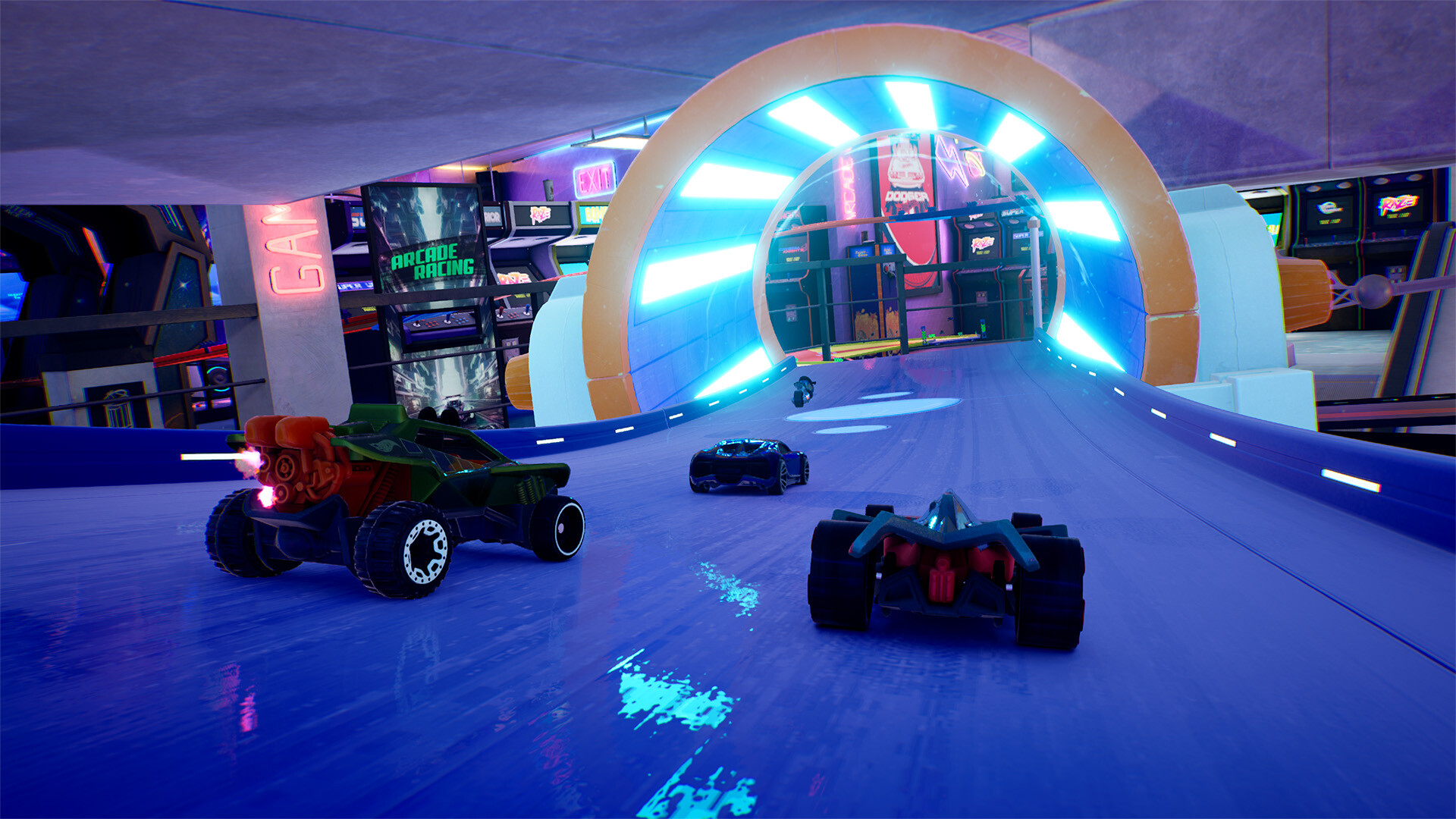 Trois voitures de course sur une piste bleue à l'intérieur d'une salle d'arcade futuriste. Des néons et des enseignes sont visibles.