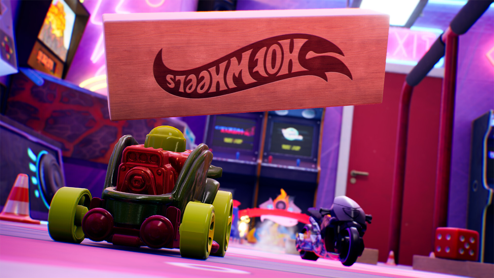 Une boîte Hot Wheels est suspendue au-dessus d'une voiture jouet verte. Une voiture de course violette en arrière-plan.