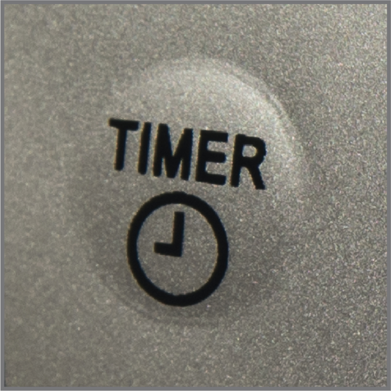 Gros plan sur un bouton gris avec le mot TIMER et un symbole d'horloge.