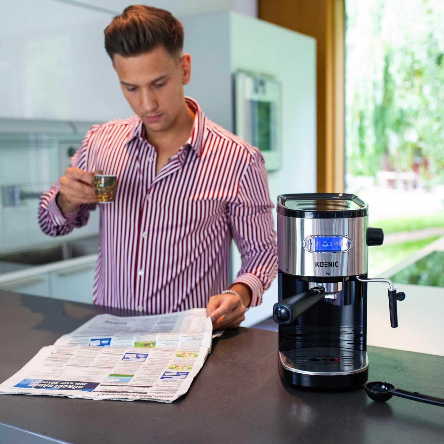 Homme lisant journal, tasse à la main, machine à café.