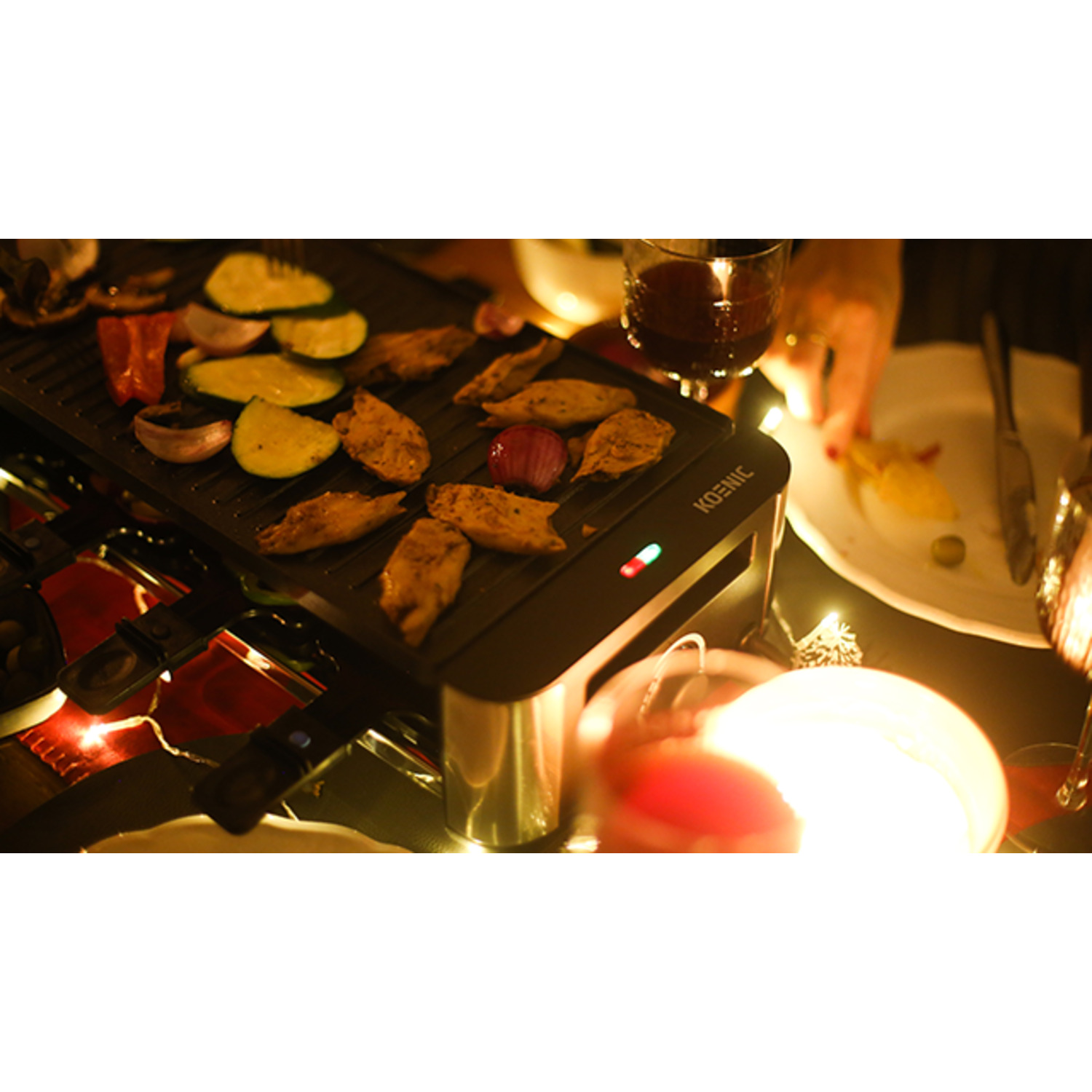 Food on a raclette grill, with a person's hand and candle lights.