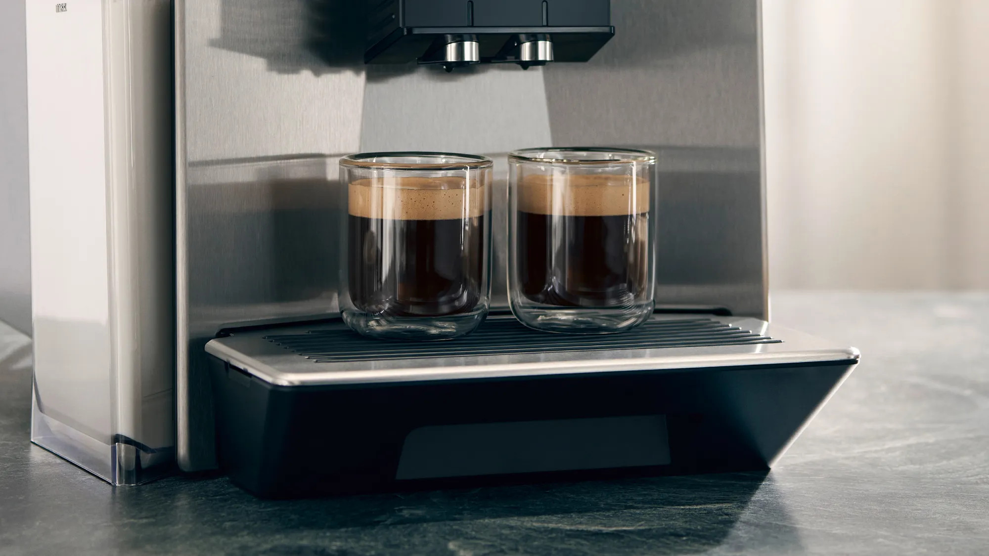 Dwie szklanki z kawą parzoną przez ekspres do kawy.