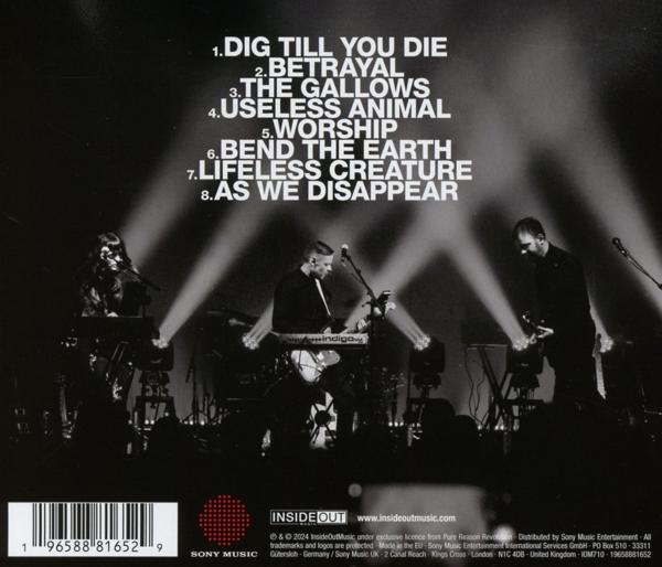 Rückseite einer CD-Hülle, mit einer Band auf der Bühne und einer Liste von Titeln.