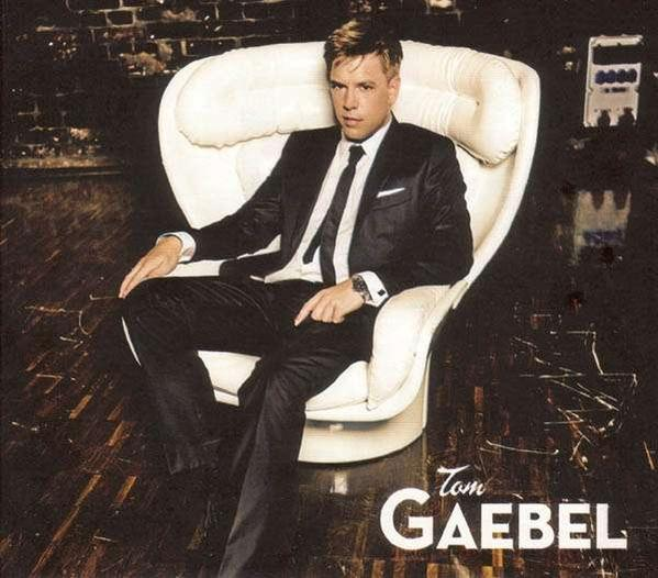Albumcover für Tom Gaebel. Zeigt einen Mann im Anzug, der in einem weißen Stuhl sitzt. Dunkler Hintergrund.