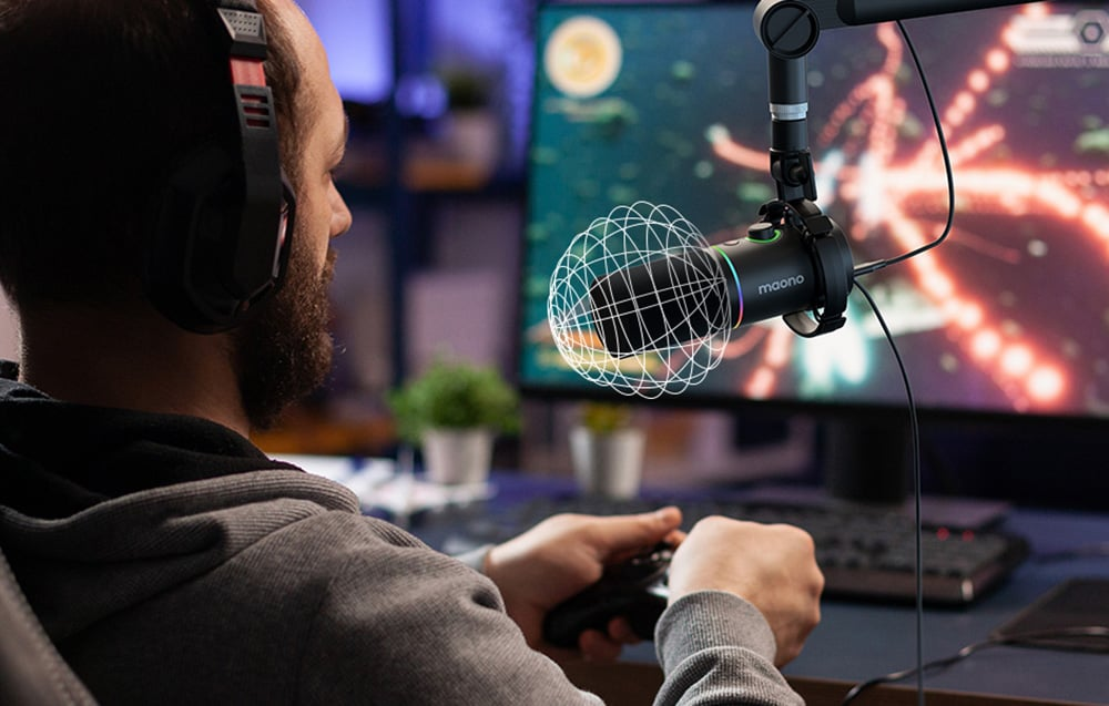Un uomo che gioca, con le cuffie e un controller, con un microfono in vista.