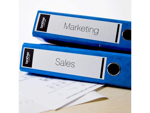 Two blue file folders labeled 'Marketing' and 'Sales' on a desk.