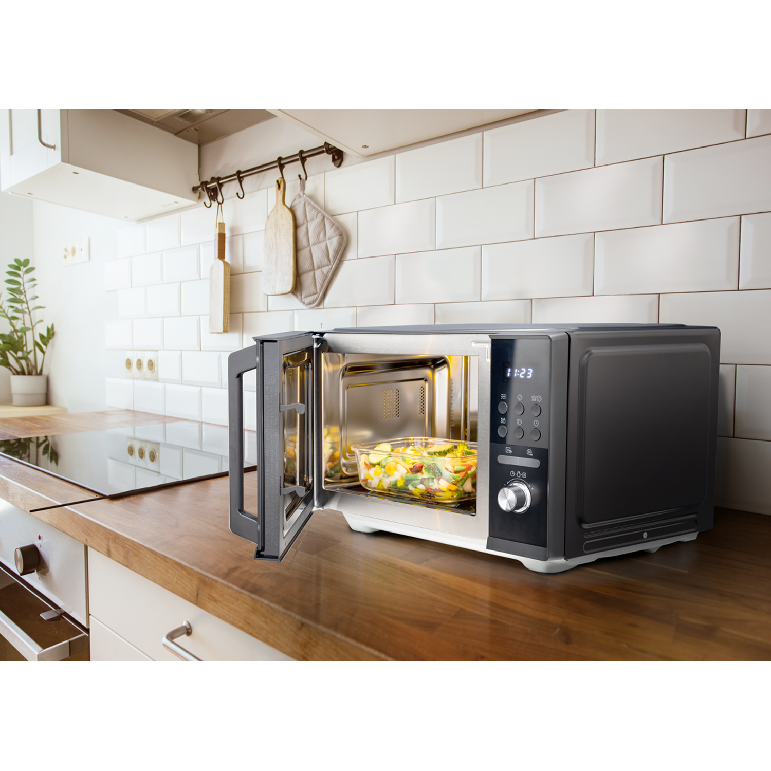A microwave oven on a wooden countertop with the door open, showing food inside.