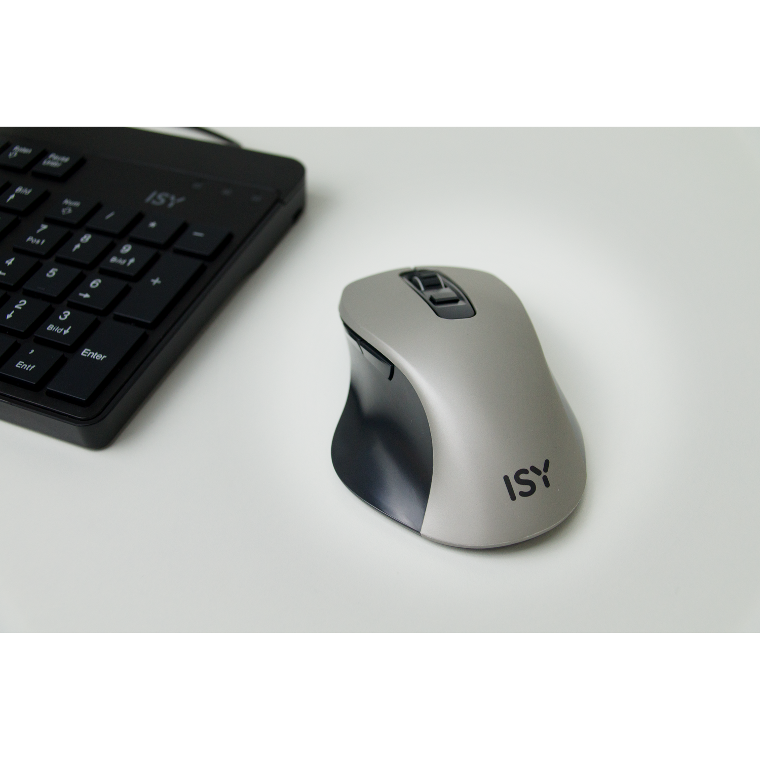 A grey computer mouse and a black number pad rest on a white surface. The mouse has the 'ISY' logo on it.