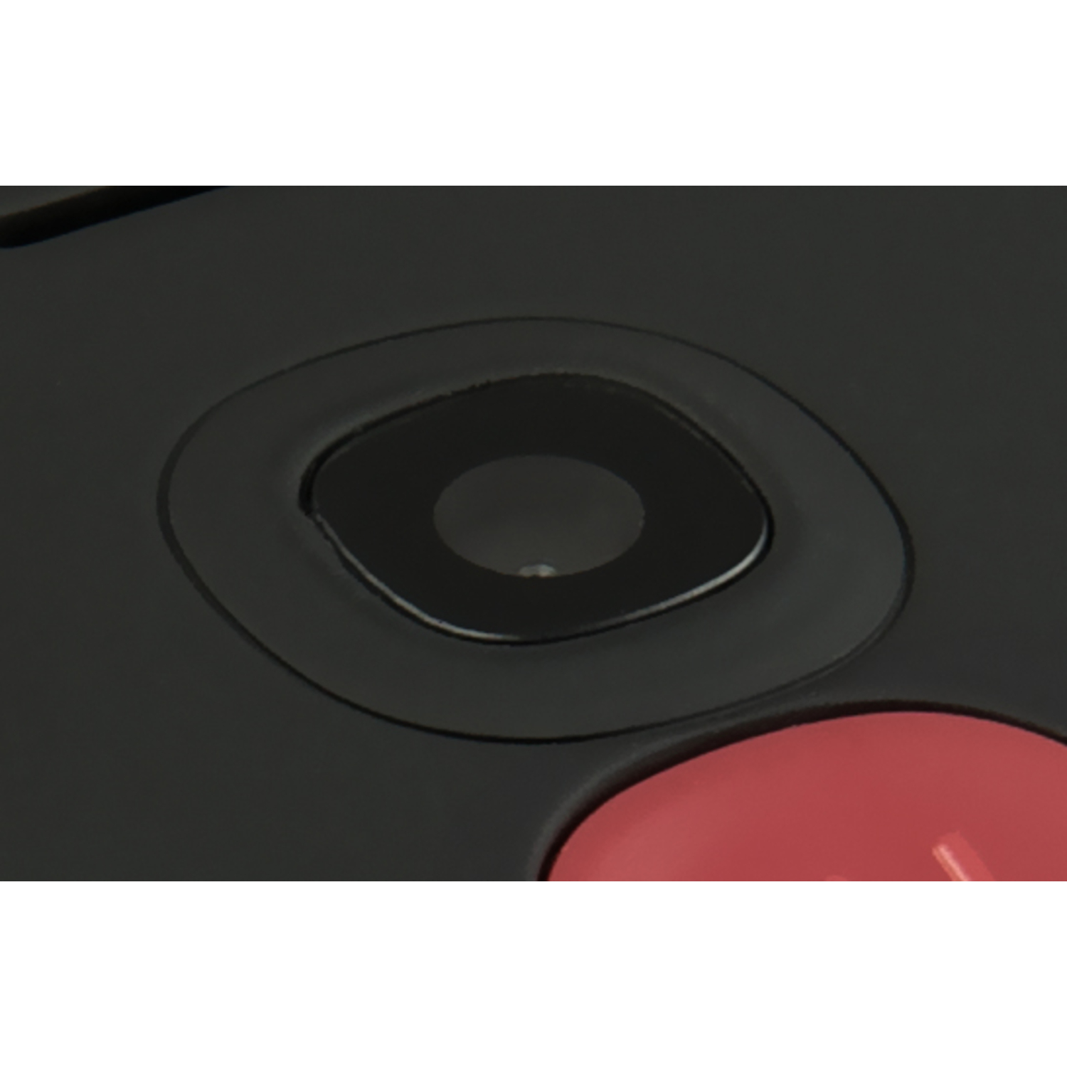 Een close-up van een zwart object met een ronde lens en een rood gedeelte.