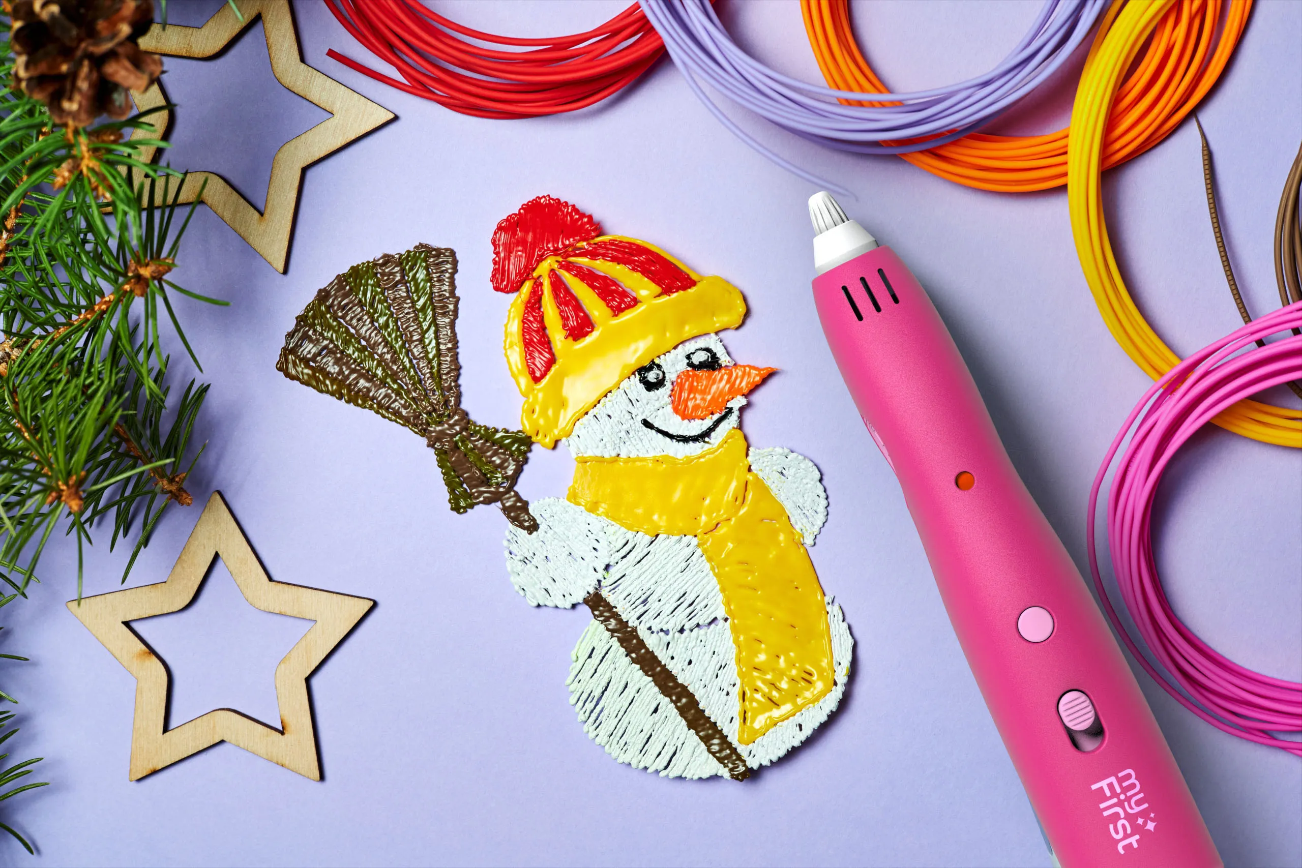 Un bonhomme de neige fait avec un stylo 3D rose sur une surface violette, entouré de filaments et d'étoiles.