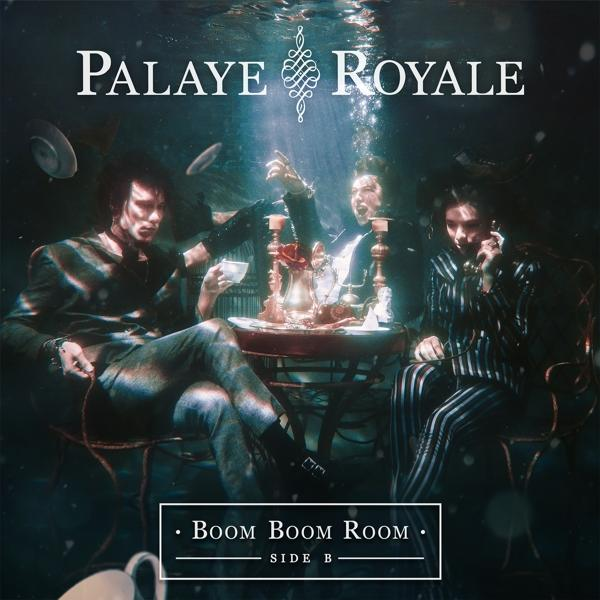 Három ember ül a víz alatt egy asztalnál, lebegő tárgyak és a Palaye Royale felirat veszi őket körül.